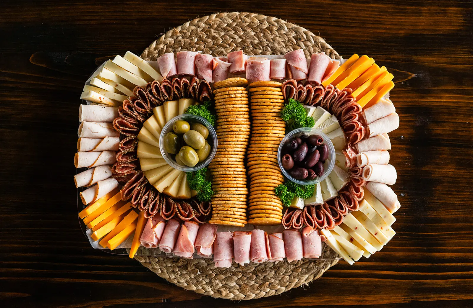 An abundant charcuterie platter arranged on a woven tray