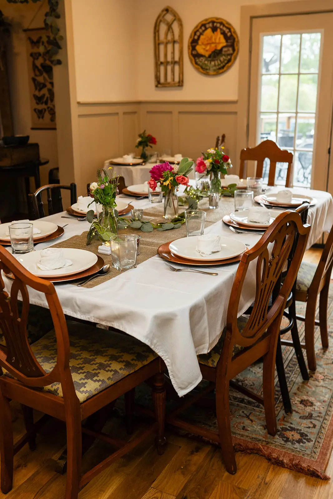 A long event table set with white linens and flowers