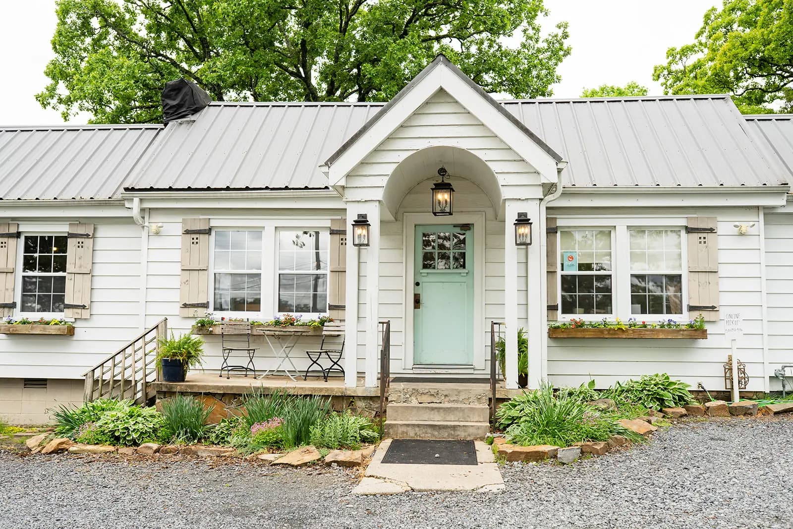The Humble Crumb bakery, a white cottage with a mint front door and arched portico