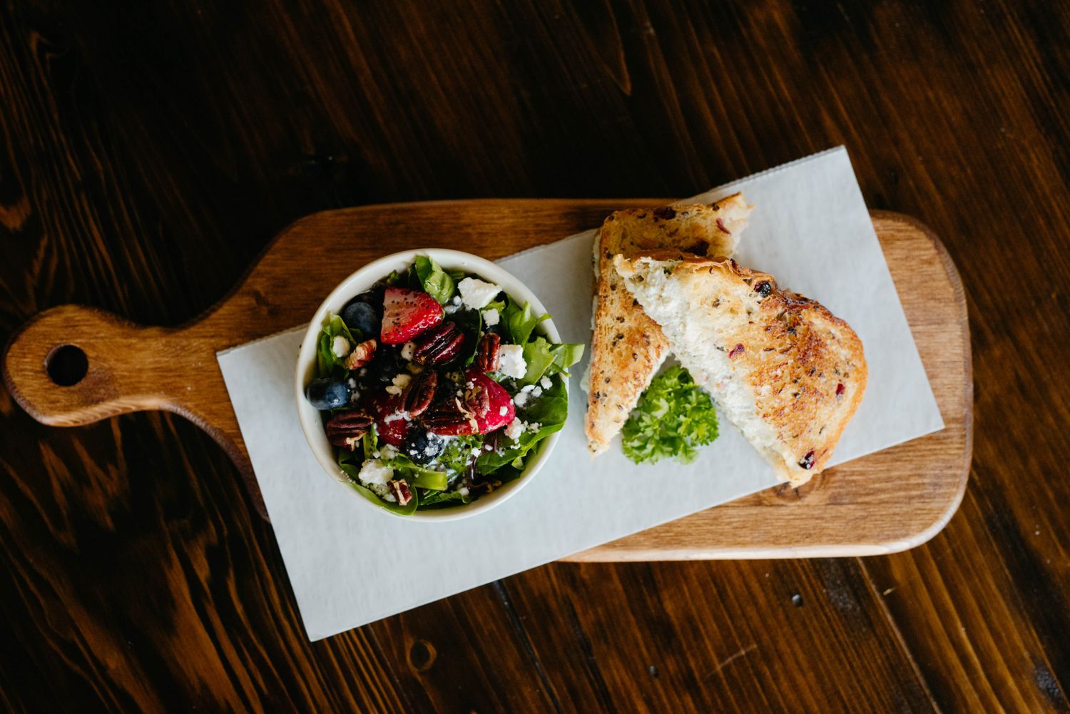 Grilled chicken salad sandwich on cranberry wild rice bread with a strawberry spinach salad