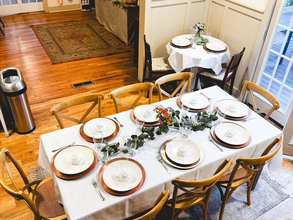 Room arranged with white tablecloths for a private gathering